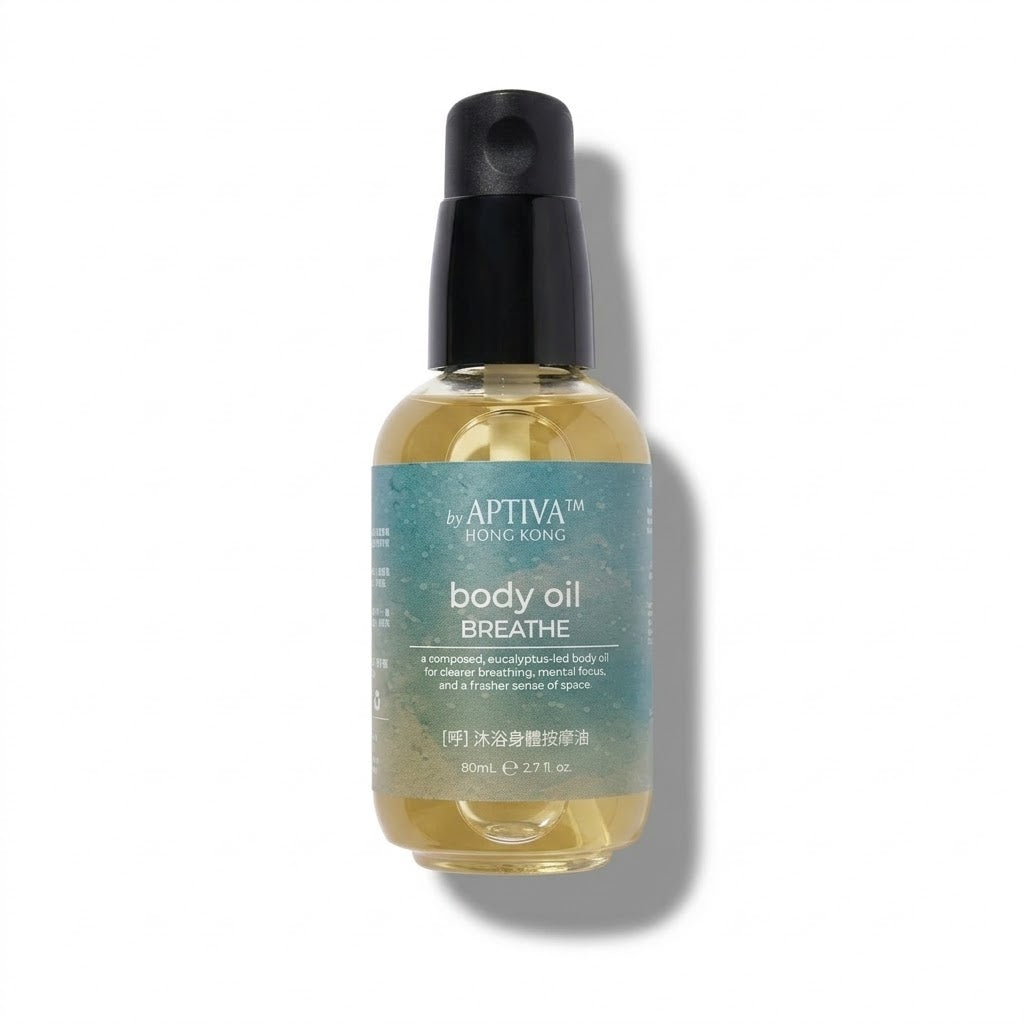 A bottle of APTIVA BREATHE body oil by By Apthiva Hong Kong, featuring a black spray pump and a translucent teal label over a golden-yellow oil, set against a plain white background with a soft shadow.